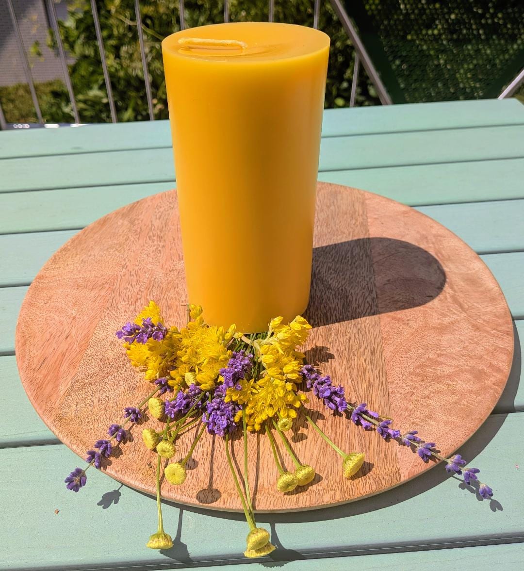 Breiter großer Bienenwachsstumpen auf Holzscheibe mit Lavendel